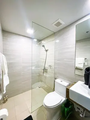 a bathroom with a toilet and a shower and a sink at Spacious 3BR condo across Okada Manila and Solaire in Manila