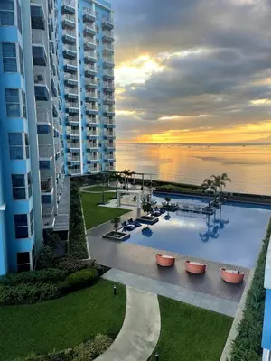 a view of a resort with a pool and the ocean at Spacious 3BR condo across Okada Manila and Solaire in Manila