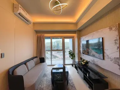 a living room with a couch and a large window at Luxury 1BR across Okada, Solaire in Manila