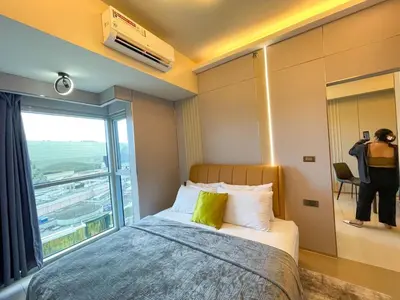 a hotel room with a bed and a large window at Luxury 1BR across Okada, Solaire in Manila
