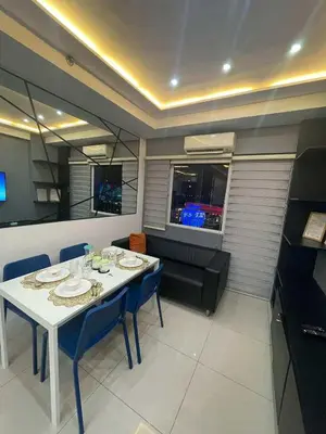 a dining room with a white table and blue chairs at Kys 3 staycation near NAIA mall of asia in Manila