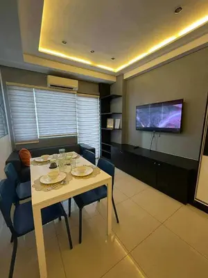 a dining room with a table and chairs and a tv at Kys 3 staycation near NAIA mall of asia in Manila