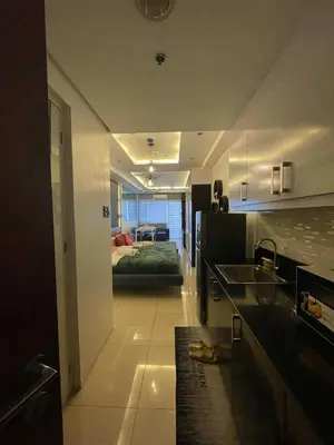 a kitchen with a bed in the middle of a room at Kys 3 staycation near NAIA mall of asia in Manila