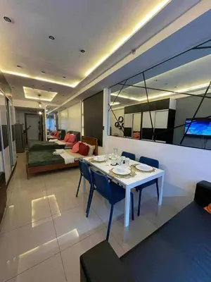 a living room with a bed and a table and chairs at Kys 3 staycation near NAIA mall of asia in Manila