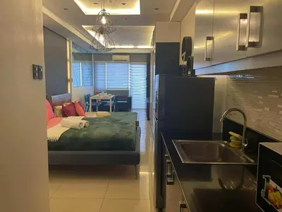 a room with a bed and a kitchen with a sink at Kys 3 staycation near NAIA mall of asia in Manila
