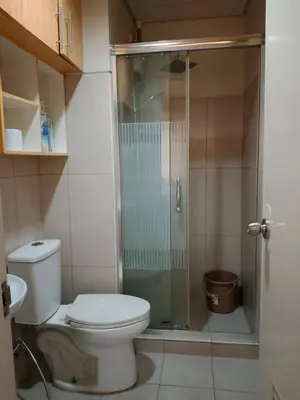 a bathroom with a toilet and a glass shower at Kys 4 staycation mall of asia in Manila