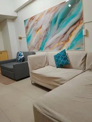 a living room with a couch and a painting on the wall at Kys 4 staycation mall of asia in Manila