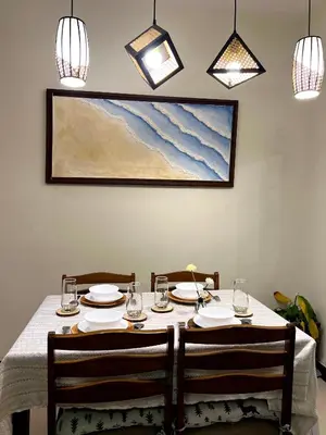 a dining table with two chairs and a painting on the wall at Jungle Escape in Manila