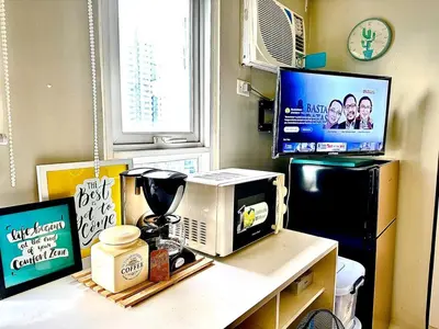 a kitchen counter with a microwave and a tv at Elegant Studio at Ortigas Business District, Pasig City in Manila