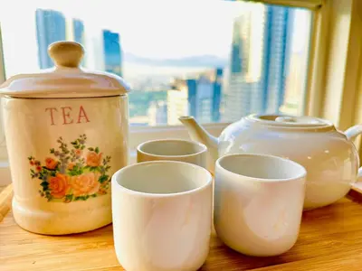 a tea pot and cups on a table with a window at Elegant Studio at Ortigas Business District, Pasig City in Manila