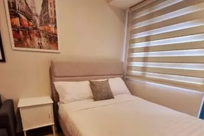 a small bedroom with a bed and a window at Cosmopolitan Comfort Makati 1 BR Wonder 300MB 2428 Internet in Manila