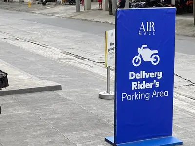 a sign for a parking area with a motor scooter at Cosmopolitan Comfort Makati 1 BR Wonder 300MB 2428 Internet in Manila