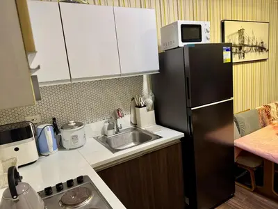 a kitchen with a sink and a refrigerator at 3 Bedroom Air condo Pool Perfect Holiday Gym Swim 300 Mbps in Manila