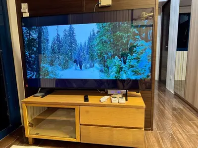 a flat screen tv sitting on top of a wooden entertainment center at 3 Bedroom Air condo Pool Perfect Holiday Gym Swim 300 Mbps in Manila