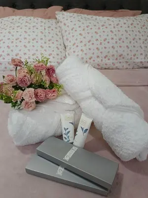 a couple of towels and two candles on a bed at Vanilla Suites Mall of Asia Complex in Manila