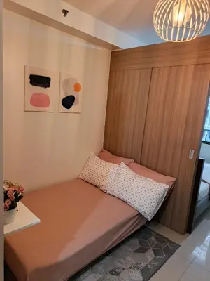 a small bed in a corner of a room at Vanilla Suites Mall of Asia Complex in Manila