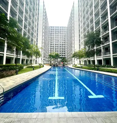 a large swimming pool in a city with tall buildings at Vanilla Suites Mall of Asia Complex in Manila