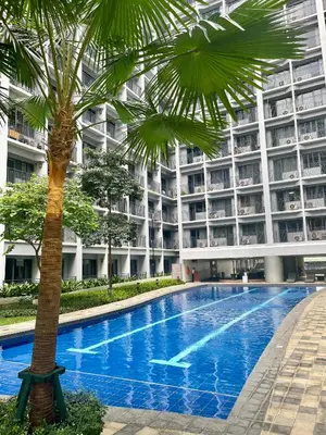 a palm tree in front of a large building at Vanilla Suites Mall of Asia Complex in Manila