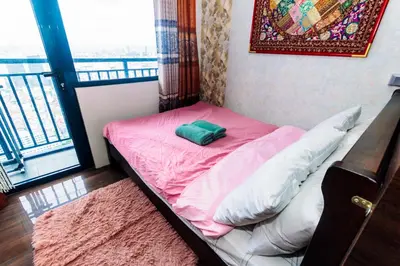 a small bed with a pink sheets and a window at Canvas & petals Blossoming Art penthouse Gym Swim Park 5716 in Manila
