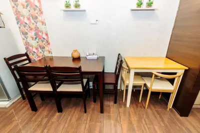 a dining room table with chairs and a wooden table at Canvas & petals Blossoming Art penthouse Gym Swim Park 5716 in Manila