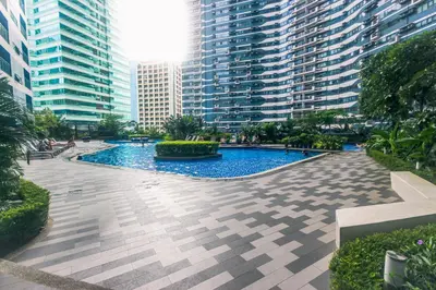 a pool in the middle of a city with tall buildings at Canvas & petals Blossoming Art penthouse Gym Swim Park 5716 in Manila