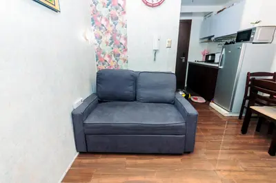 a couch sitting in a living room with a kitchen at Canvas & petals Blossoming Art penthouse Gym Swim Park 5716 in Manila