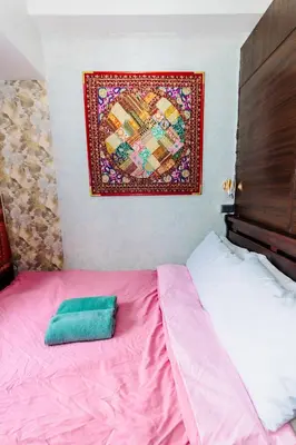 a bedroom with a pink bed and a painting on the wall at Canvas & petals Blossoming Art penthouse Gym Swim Park 5716 in Manila