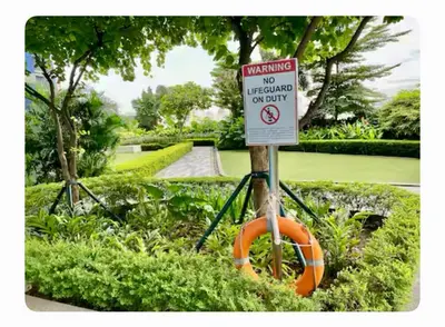 a sign in a garden with a no swimming sign at Chic Luxury Air condo 2 Bedroom Finest City Living Air Makati Gym Swim Park 300 in Manila