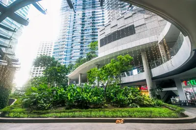 a large building with a garden in front of it at Cozy Peacock hideaway Stylish Makati Condo 300 Mbps Gym Swim Park in Manila