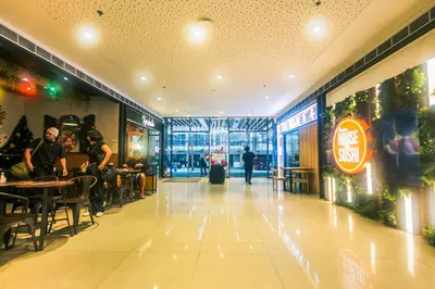 a restaurant with people sitting at tables in a building at Cozy Peacock hideaway Stylish Makati Condo 300 Mbps Gym Swim Park in Manila