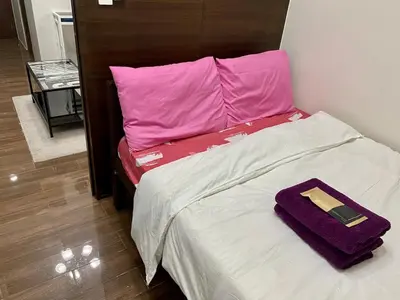 a bed with a purple pillow and a cell phone on it at Cruise Ship Condo Escape Makati 300 Mbps Gym Swim Park 2271 in Manila