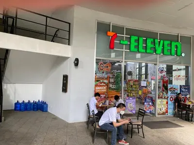 two men sitting in chairs in front of a pizza restaurant at Cruise Ship Condo Escape Makati 300 Mbps Gym Swim Park 2271 in Manila
