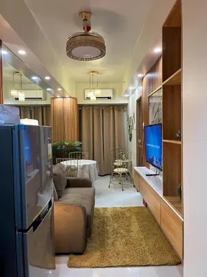 a living room with a couch and a television at Dahl's Cozy Place in Manila