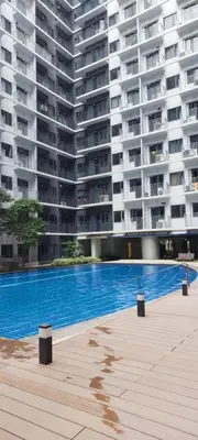 an empty swimming pool in front of a large apartment building at Dahl's Cozy Place in Manila
