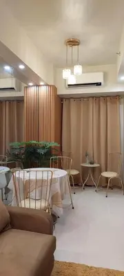 a living room with a table and chairs and a curtain at Dahl's Cozy Place in Manila