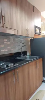 a kitchen with a sink and wooden cabinets at Dahl's Cozy Place in Manila