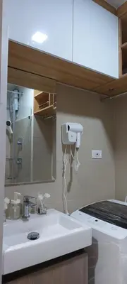 a bathroom with a white sink and a mirror at Dahl's Cozy Place in Manila