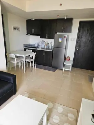 a kitchen with a refrigerator and a table and chairs at 3BR at The Rochester in Manila