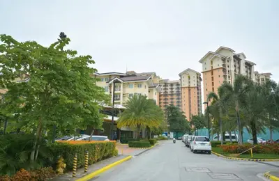 a city street with palm trees and buildings at 3BR at The Rochester in Manila