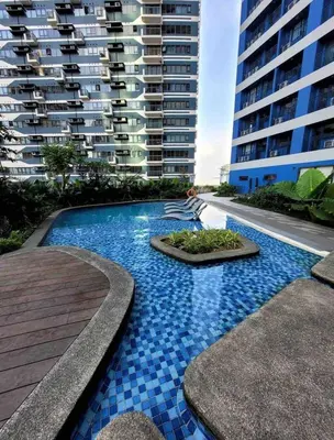a swimming pool in front of a large building at Cosmo Nest Air Skyline One BR Makati 2270 Gym Swim Park 300 Mbps in Manila
