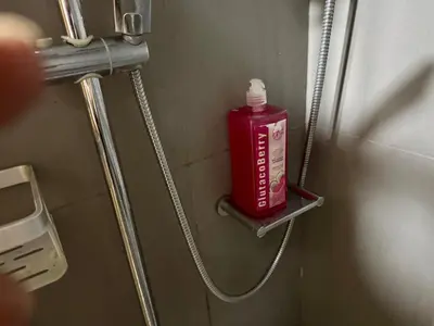 a red bottle on a shelf in a bathroom at Galloping Suite Executive Makati Suite Gym Swim Park 300 Mbps in Manila