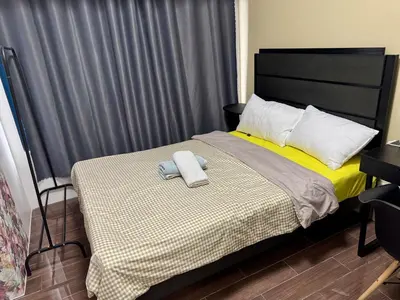a bedroom with a bed with two towels on it at Galloping Suite Executive Makati Suite Gym Swim Park 300 Mbps in Manila
