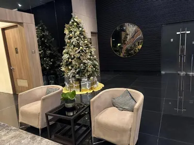 a christmas tree in a lobby with two chairs and a table at Heavenly holiday Italian Rome Air Makati Gym Swim Park 300 in Manila