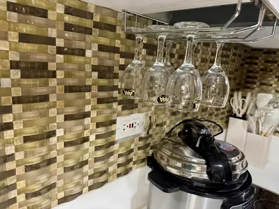 a kitchen with wine glasses hanging on a wall at Heavenly holiday Italian Rome Air Makati Gym Swim Park 300 in Manila