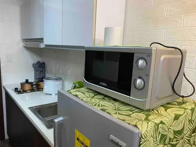 a microwave sitting on top of a counter in a kitchen at Jazz Air Rooftop Penthouse Bar Gym Swim Park 300 Mbps Air 4034 in Manila