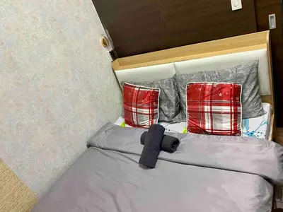 a bed with two red pillows and a black cross on it at Jazz Air Rooftop Penthouse Bar Gym Swim Park 300 Mbps Air 4034 in Manila