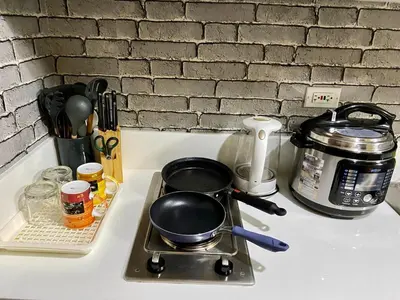 a frying pan on a stove on a kitchen counter at Makati Ayala luxury Stylish Uncle Sam condo Gym Swim Park 300 Mb 2641 in Manila