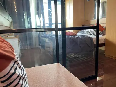 a room with a glass window with two beds at Makati Ayala luxury Stylish Uncle Sam condo Gym Swim Park 300 Mb 2641 in Manila