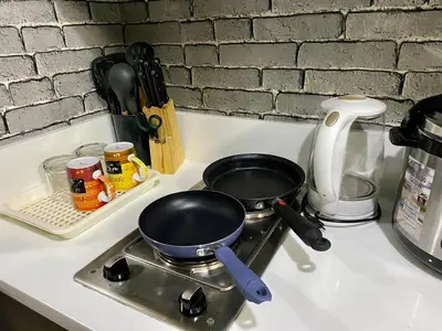a stove with two frying pans on top of it at Makati Ayala luxury Stylish Uncle Sam condo Gym Swim Park 300 Mb 2641 in Manila