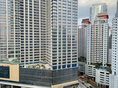 a tall building in a city with tall buildings at Makati Broadway Bliss Golden spot Gym Swim Park 300 Mbps 1940 in Manila